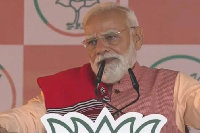 Prime Minister Narendra Modi addresses a gathering during a public meeting, in Gogamukh, Assam