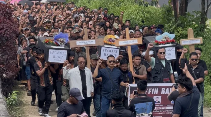 Thousands of mourners participate in the Kangpokpi Coffin Rally during a 35-kilometer funeral procession for three Loibol attack victims in Manipur.