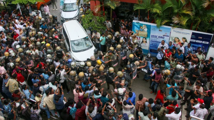 Police personnel intervene as rival political party workers gather during tense local dispute