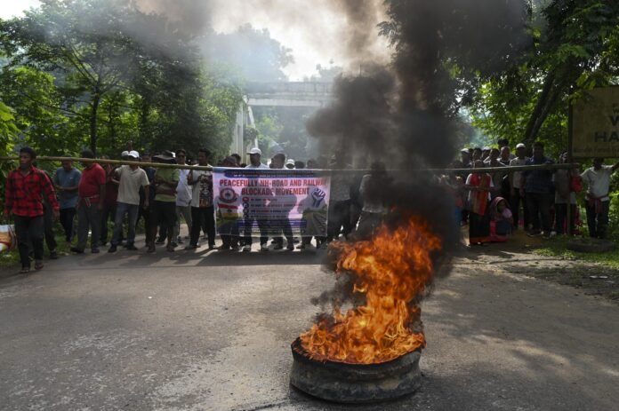 Vehicles line up along the Assam-Agartala Highway during a brief blockade organized to demand the release of rehabilitation funds.