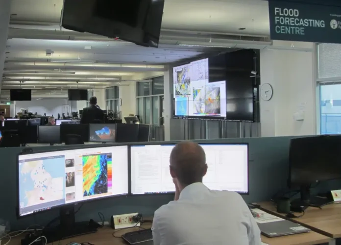 Officials monitoring real-time flood data and weather information at MDoNER's dedicated 24-hour flood monitoring control center.