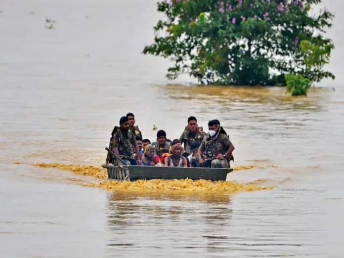Flood-affected Assam region with rescue teams conducting search operations for missing persons amid rising waters.