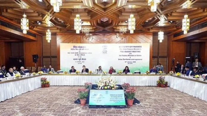 Financial experts review government budget documents while discussing welfare funding and public borrowing during a fiscal policy meeting