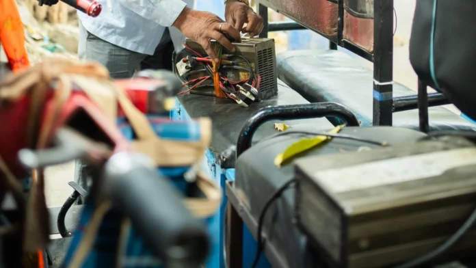 Officials inspect and disconnect an illegal electricity connection while seizing auto-charging equipment during an enforcement drive in Gandhigram.